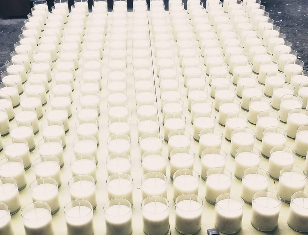 Rows of freshly poured soy candles in the SweetlyRecycled studio