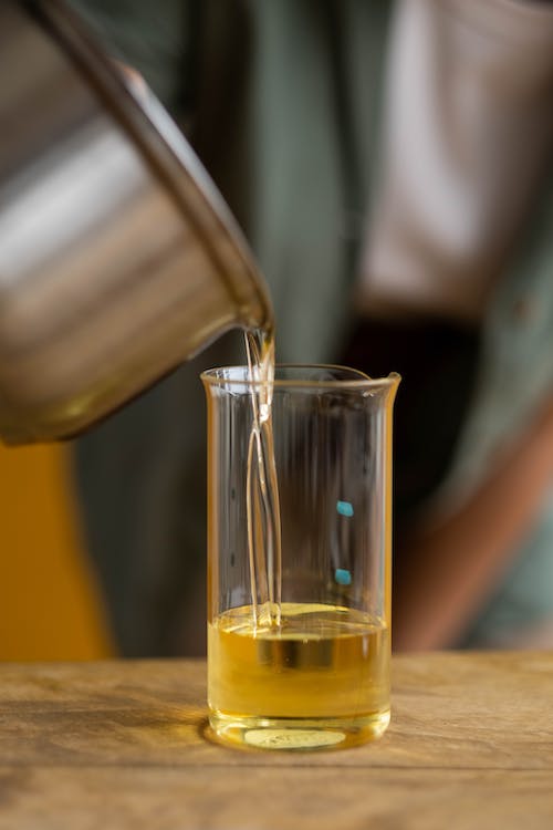 Wax being hand poured into a glass vessel in the SweetlyRecycled studio